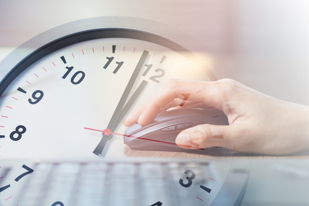 clock with a laptop overlay of a hand moving a computer mouse