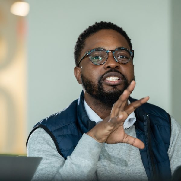 Man sitting in an MBA classroom explaining a business concept