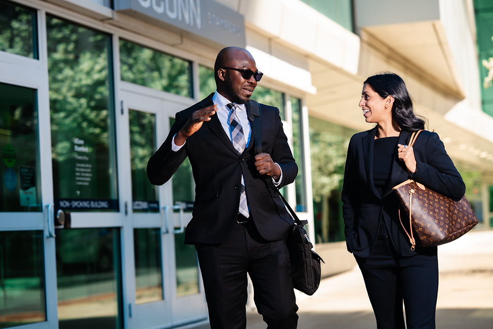 Two graduate students strolling by the UConn Stamford campus entrance